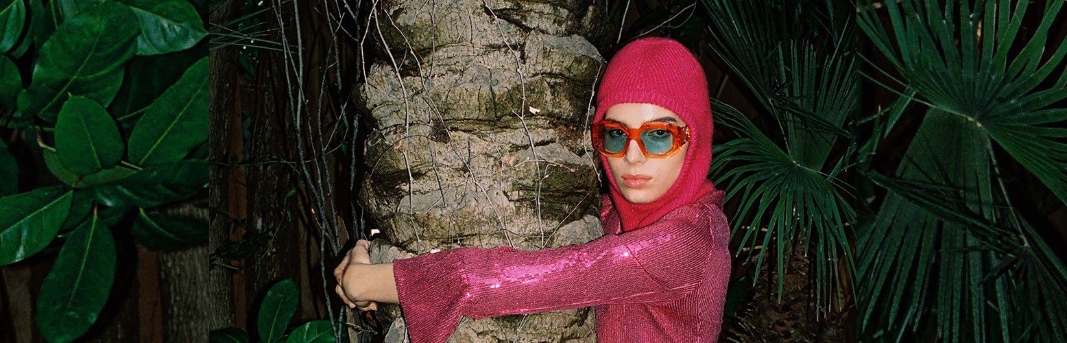 Person in pink outfit hugging tree at night