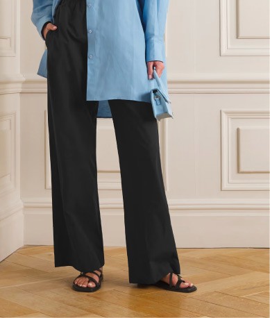 Person wearing black wide-leg pants and blue shirt