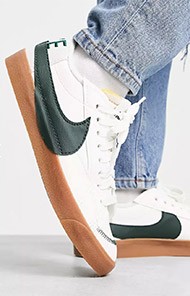 White sneakers with green swoosh and gum soles