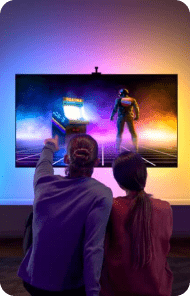 Two people watching colorful arcade game on screen