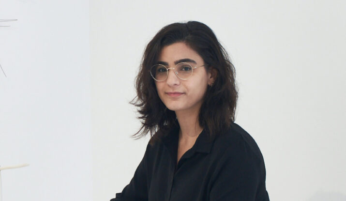 Woman with glasses in black shirt against white background