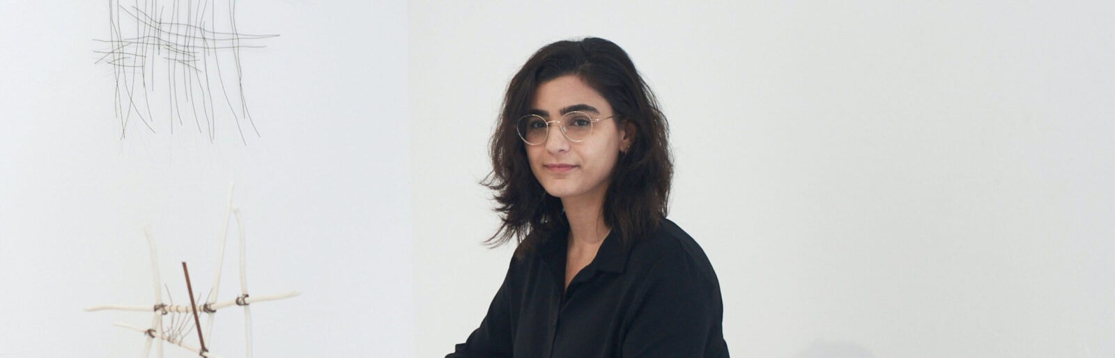 Woman with glasses in black shirt against white background