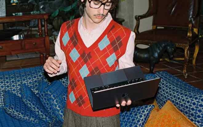 Person with glasses using a laptop indoors
