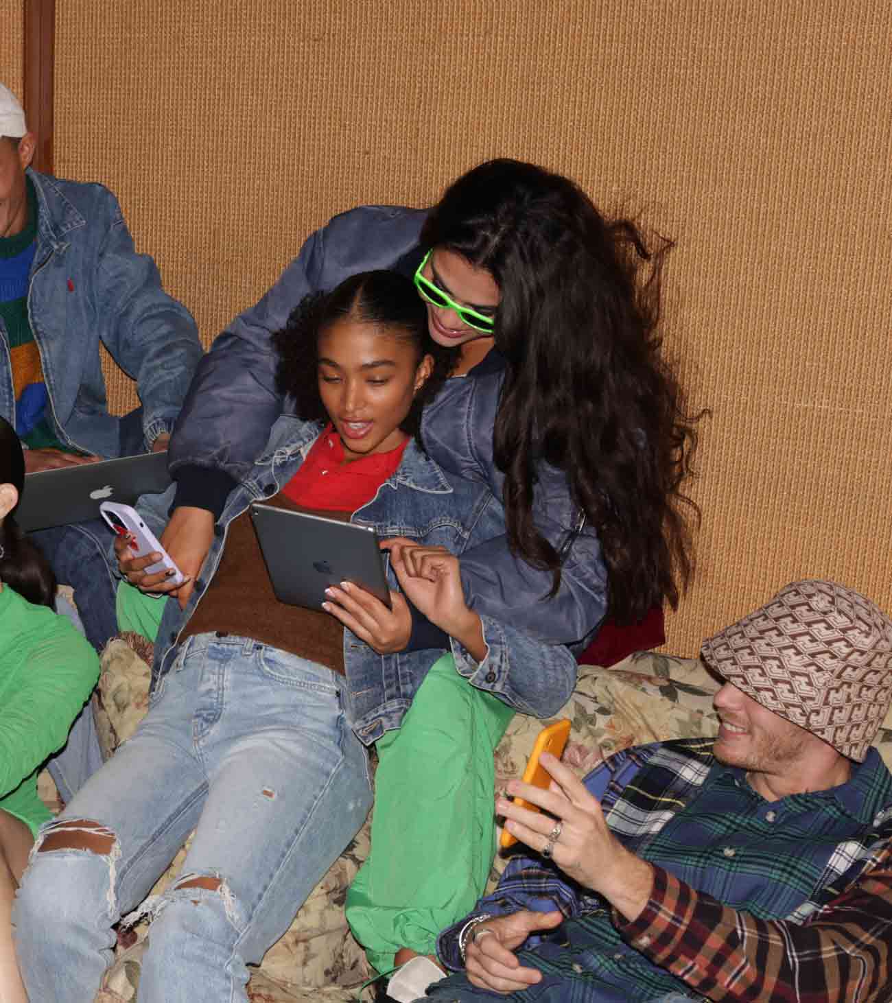 Group of friends using devices and smiling
