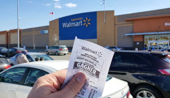 Hand holding Walmart receipt outside Walmart store