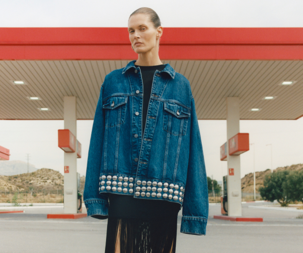 Woman wearing oversized denim jacket with studs