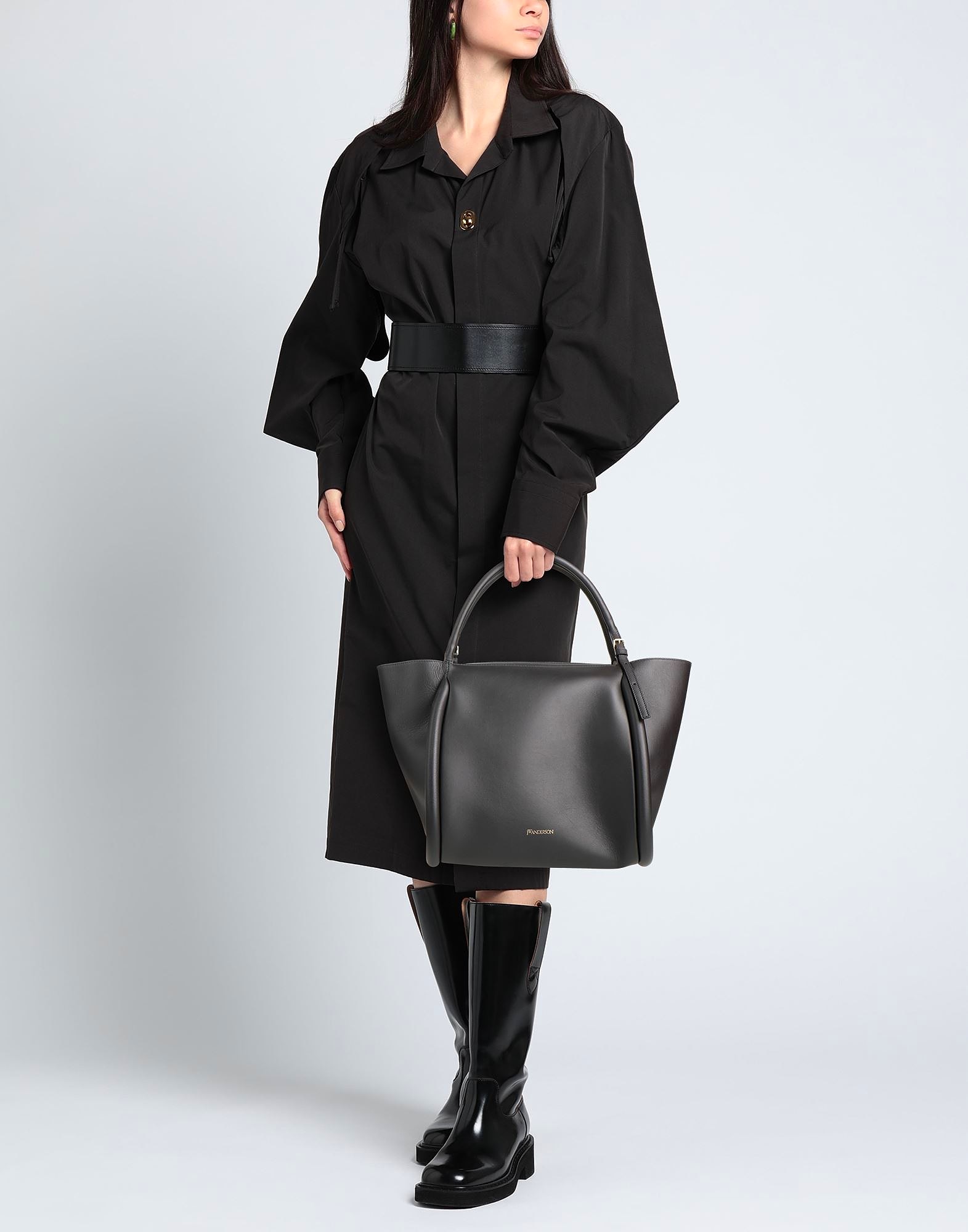Woman in black dress holding large black handbag