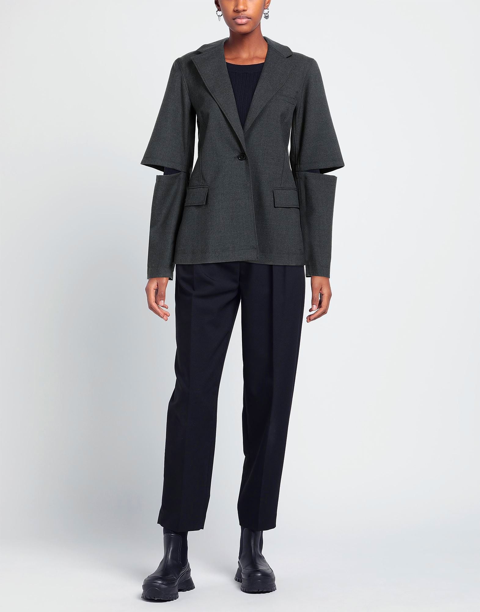 Model wearing dark tailored jacket with cutout sleeves