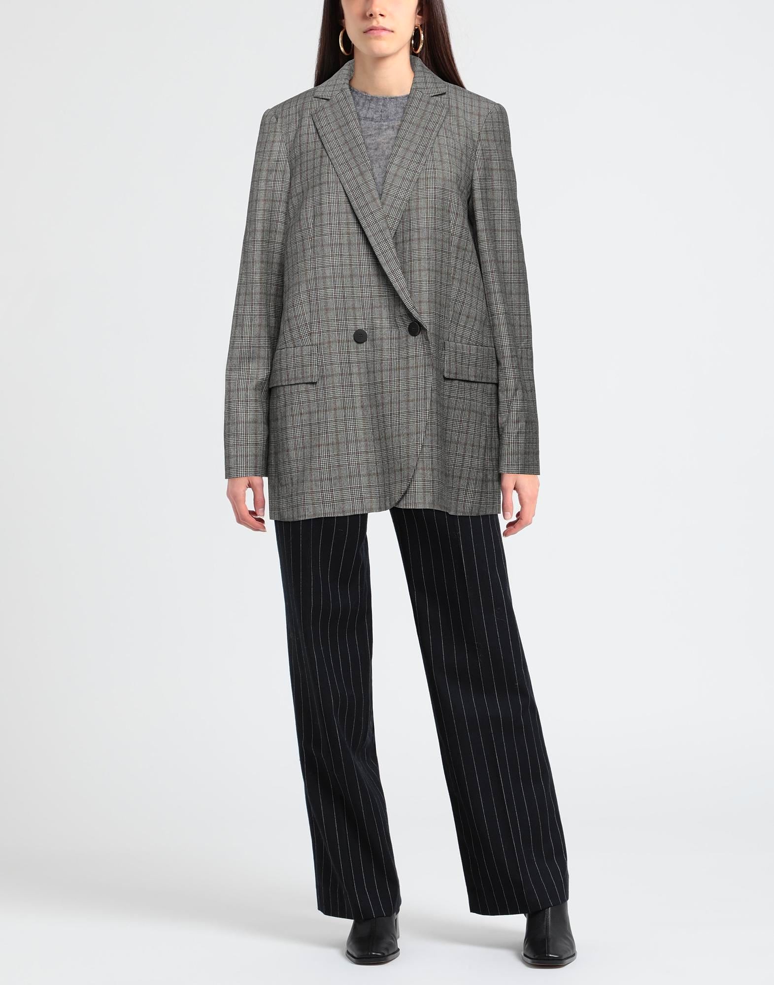 Woman wearing oversized plaid blazer and pinstripe pants