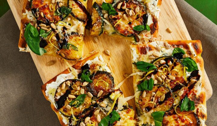 Four vegetable flatbread slices with greens and seeds