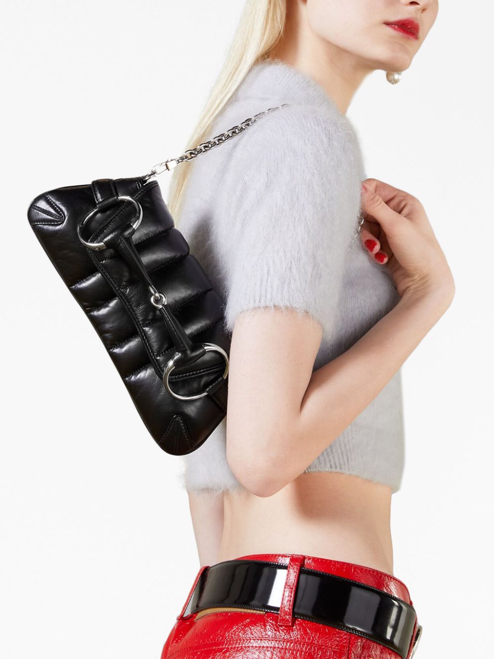 Woman carrying black leather handbag over shoulder