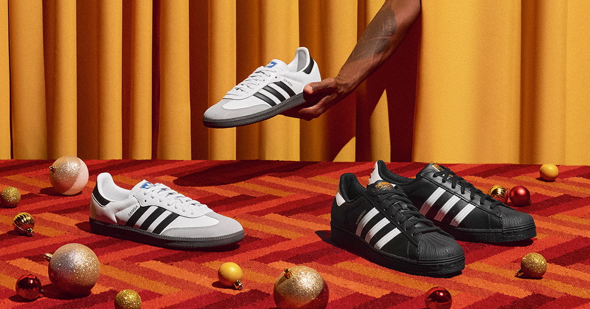 White and black Adidas sneakers on red carpet
