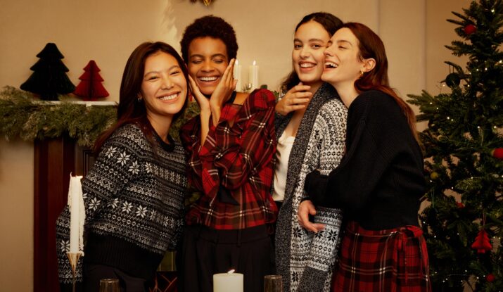 Four women smiling together during holiday celebration