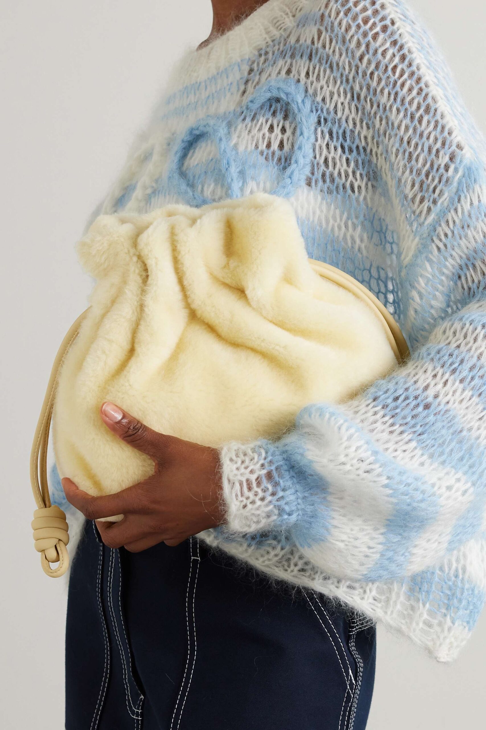 Person holding soft yellow fuzzy drawstring bag