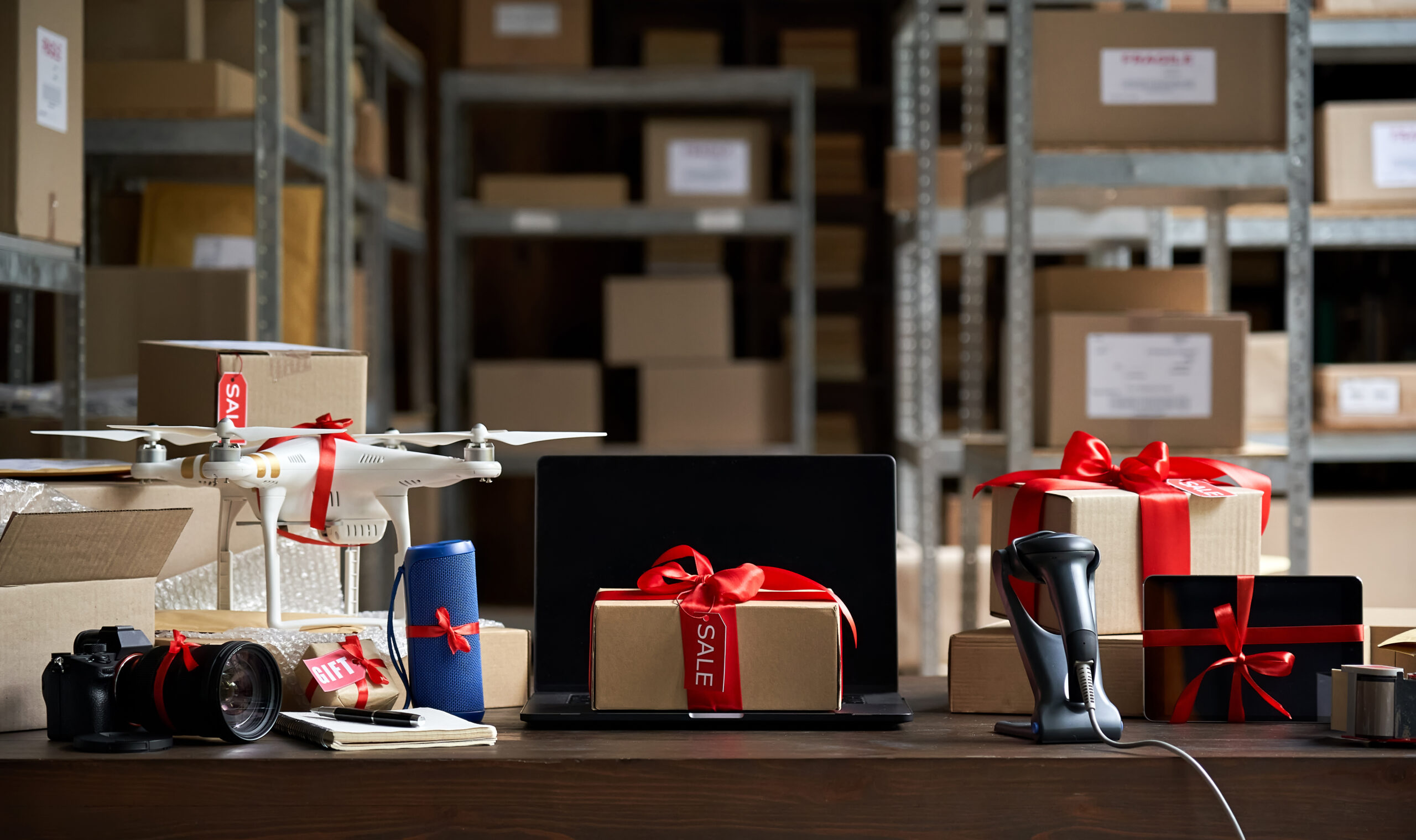 Warehouse table with gift-wrapped tech gadgets and boxes
