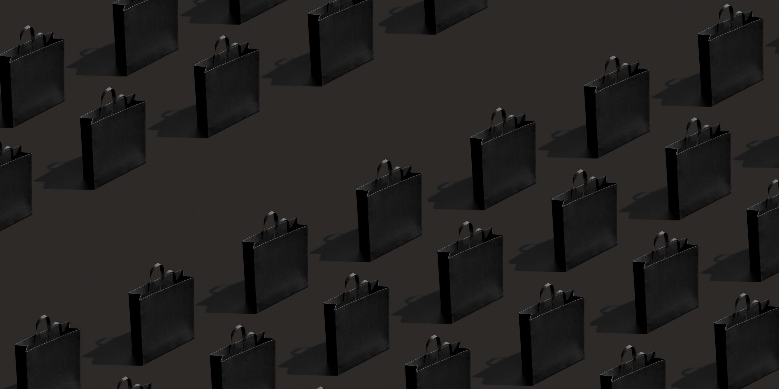 Rows of black paper shopping bags casting shadows