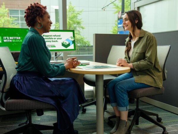 Two women discussing finances in office setting