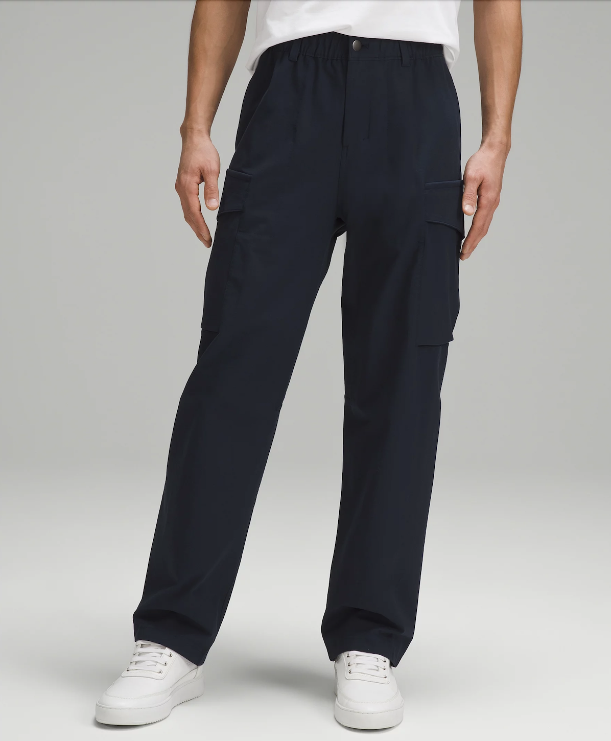 Man wearing black cargo pants and white sneakers