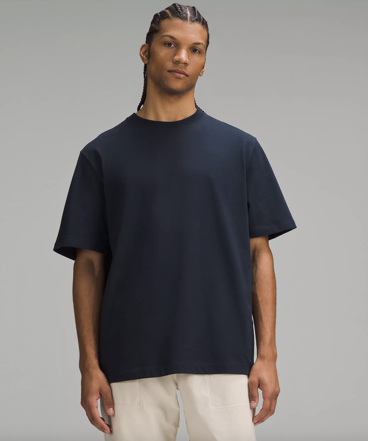 Man wearing navy blue t-shirt and cream pants