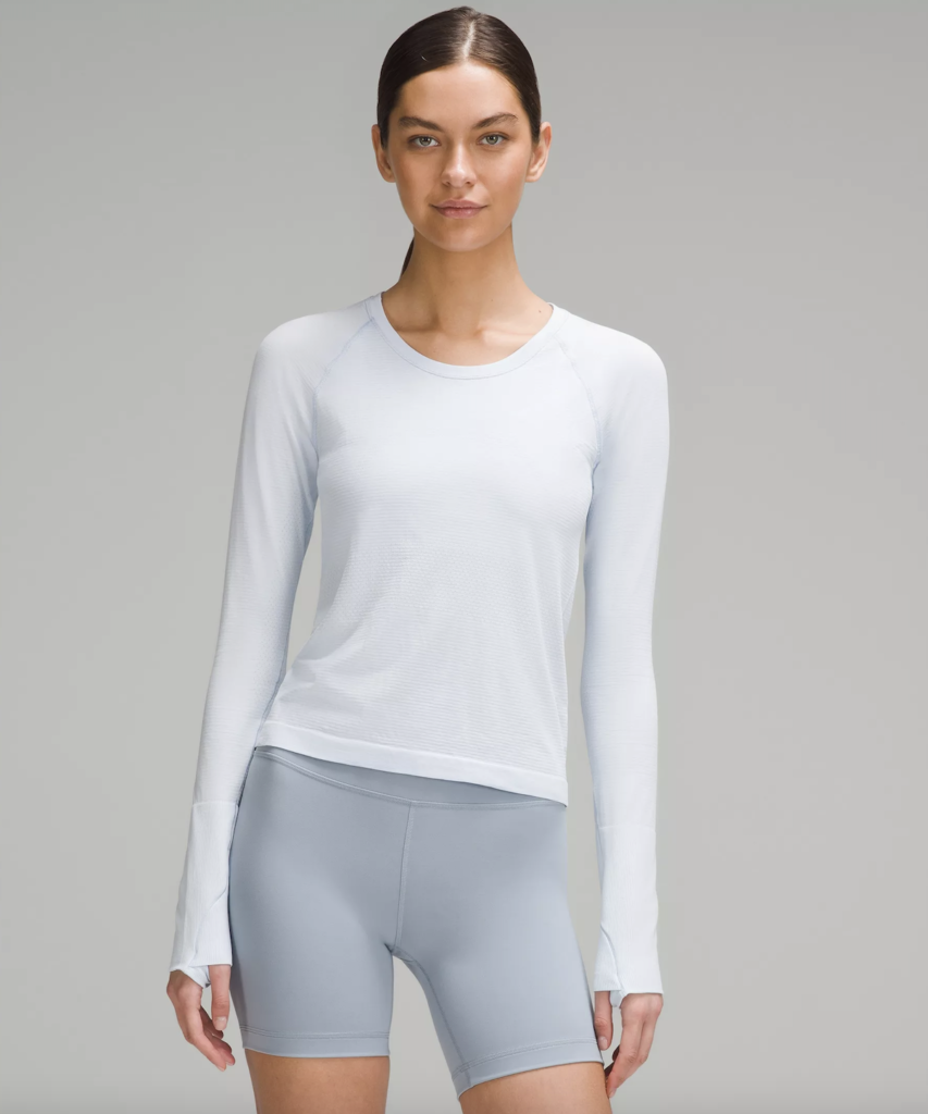 Woman wearing light blue long-sleeve top and shorts