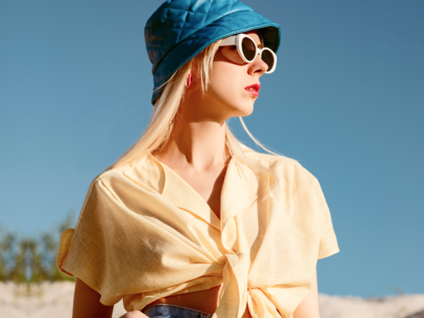 Woman in yellow shirt, blue hat, sunglasses