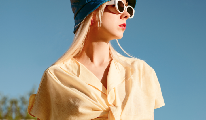 Woman in yellow shirt, blue hat, sunglasses