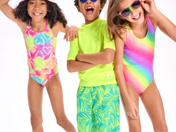 Children in colorful swimsuits and sunglasses smiling