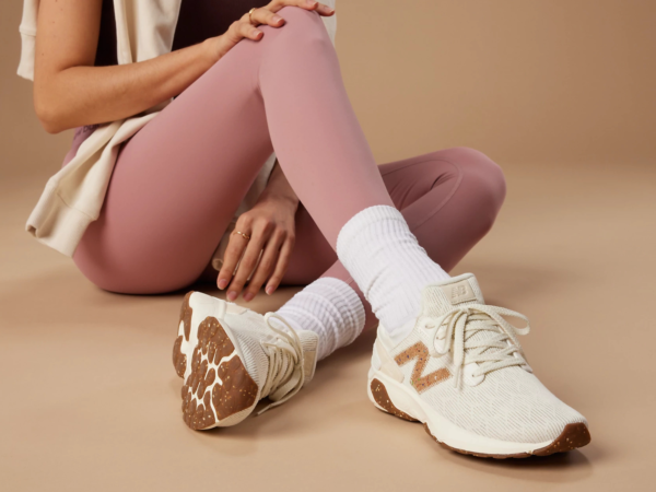 Person wearing pink leggings and cream sneakers sitting down