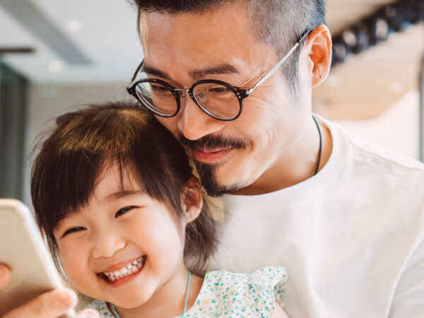 Father and daughter smiling at smartphone together