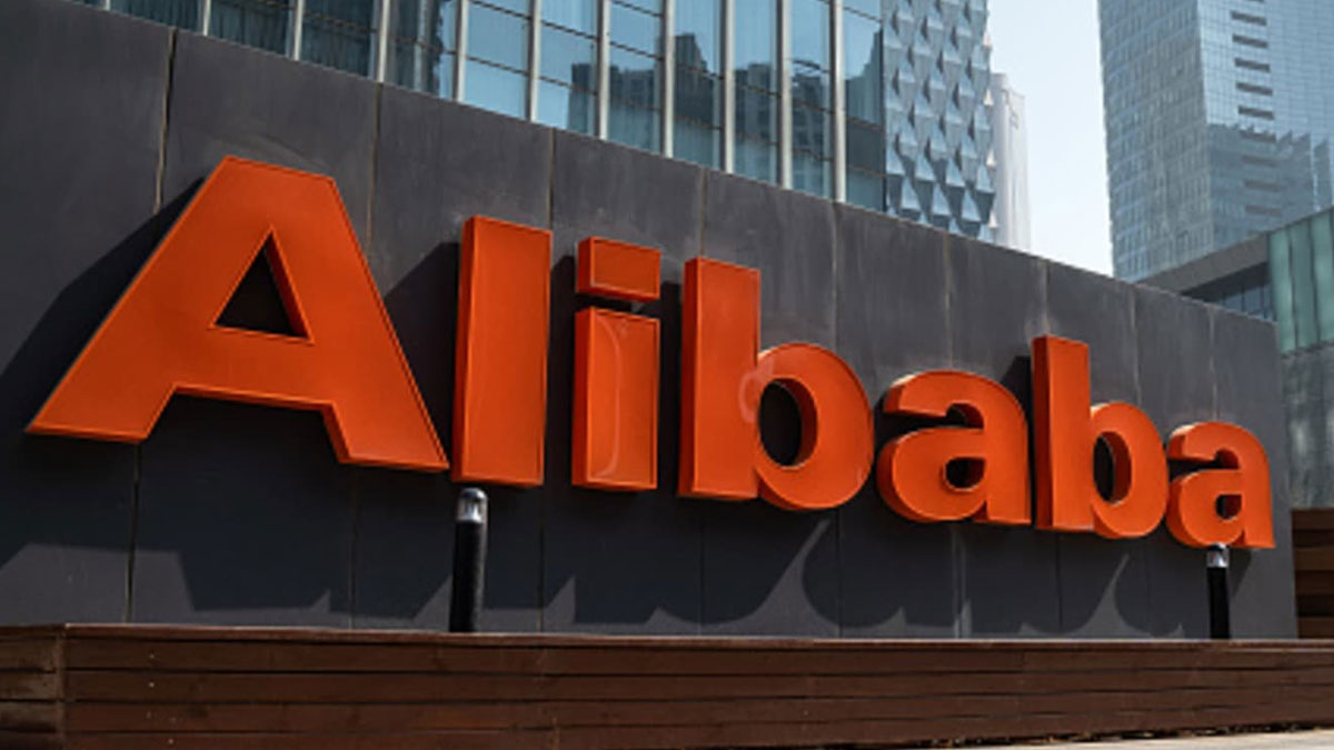 Orange Alibaba sign on dark wall with skyscrapers