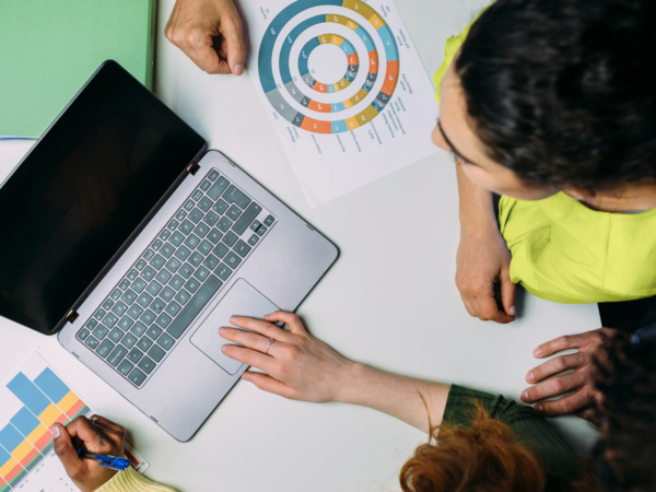 People collaborating over laptop and charts