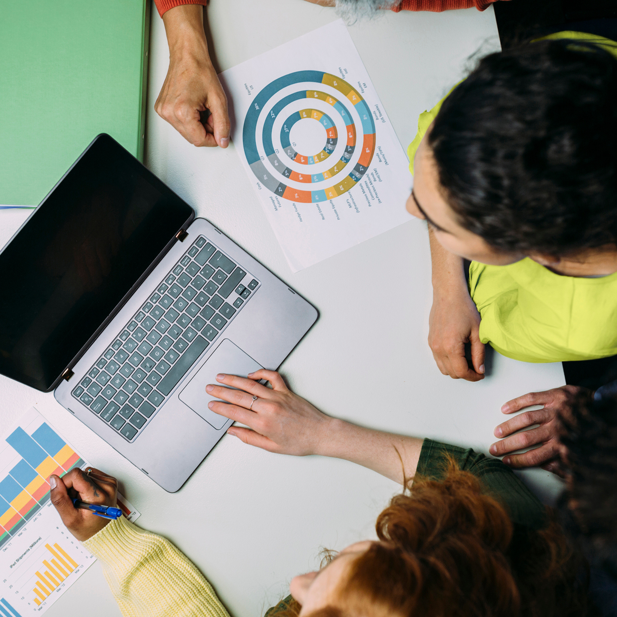 People collaborating over laptop and charts