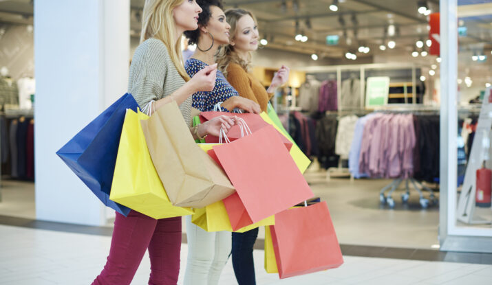 Three women carrying colorful shopping bags