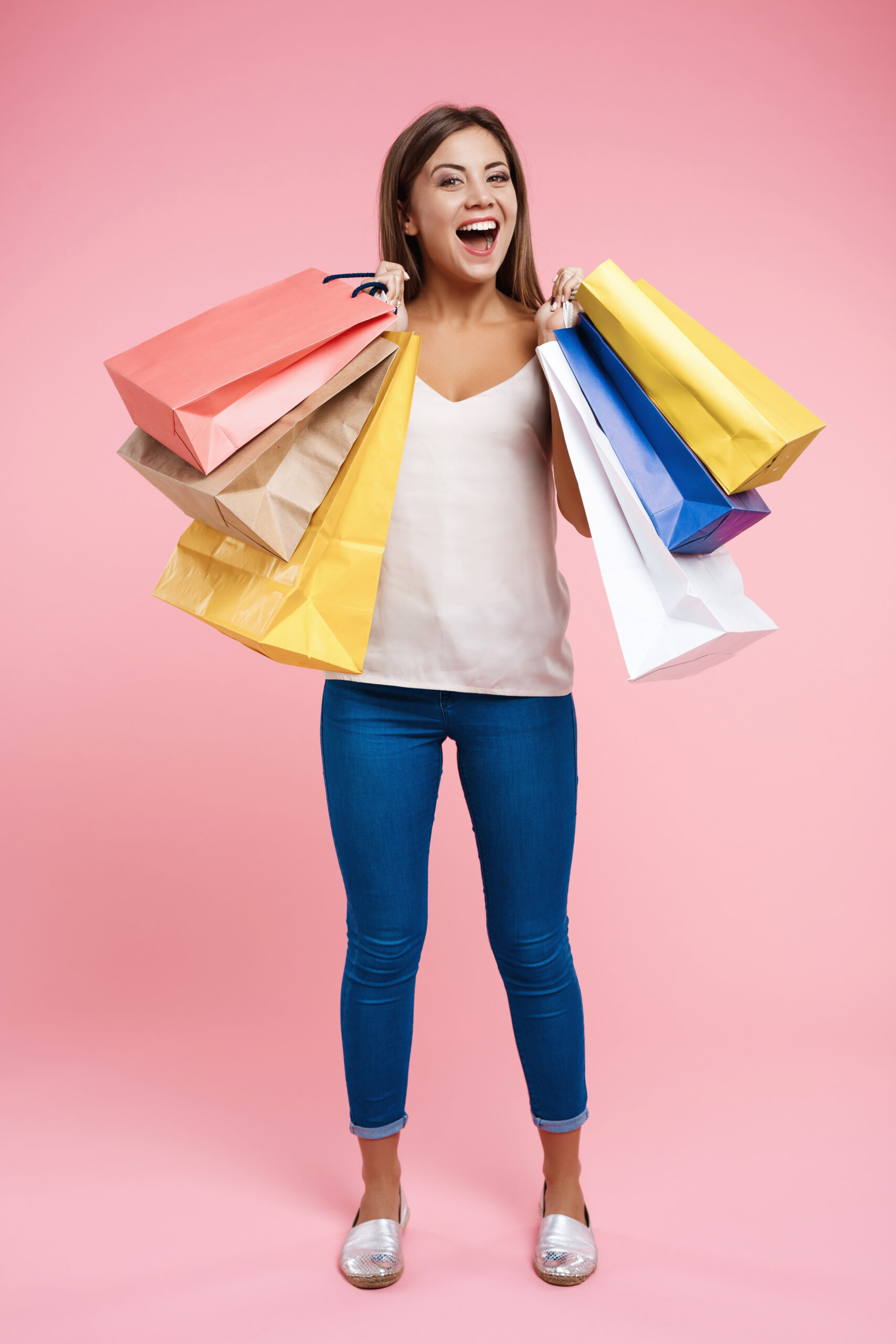 Happy woman holding colorful shopping bags