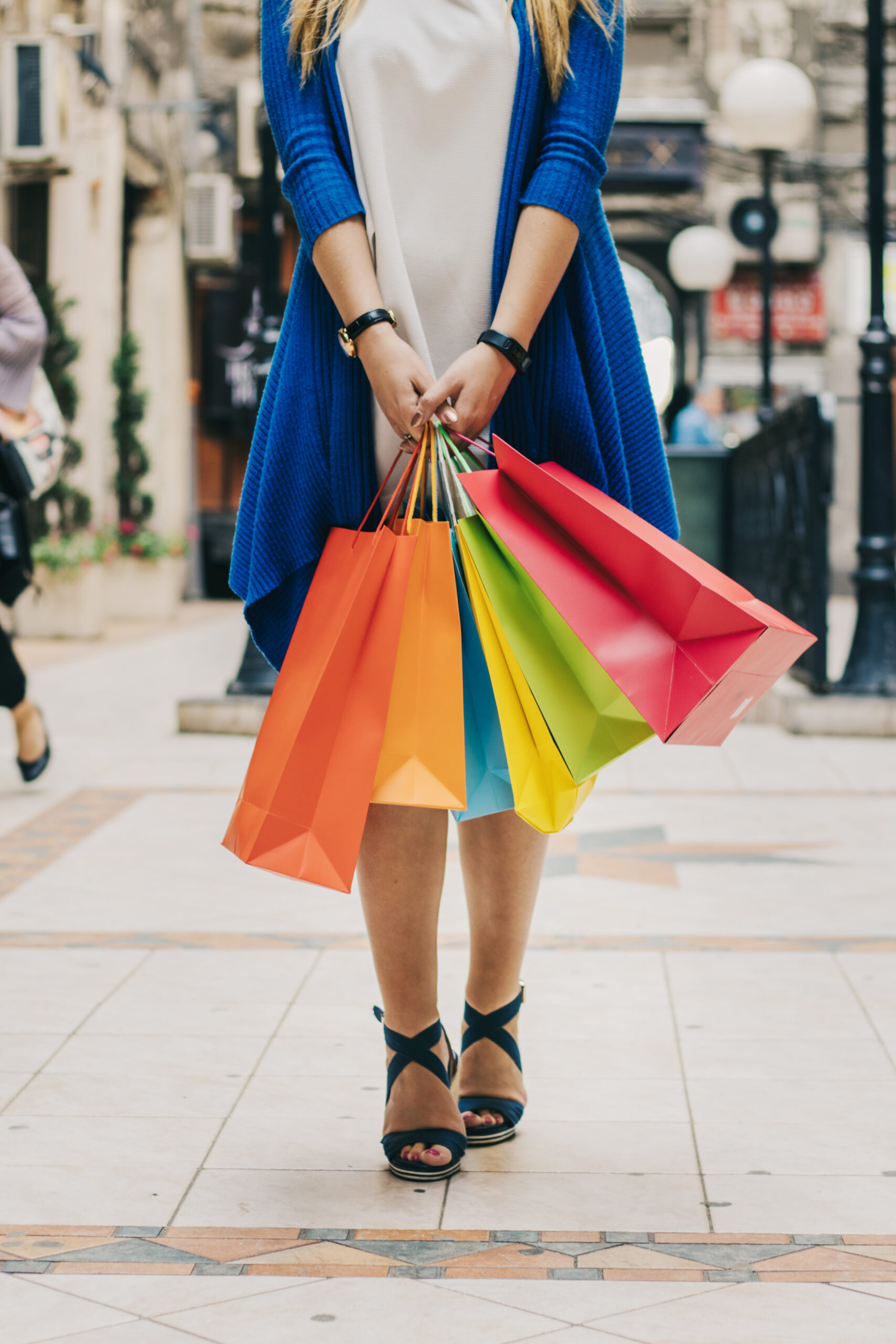 Woman holding multicolored shopping bags outdoors