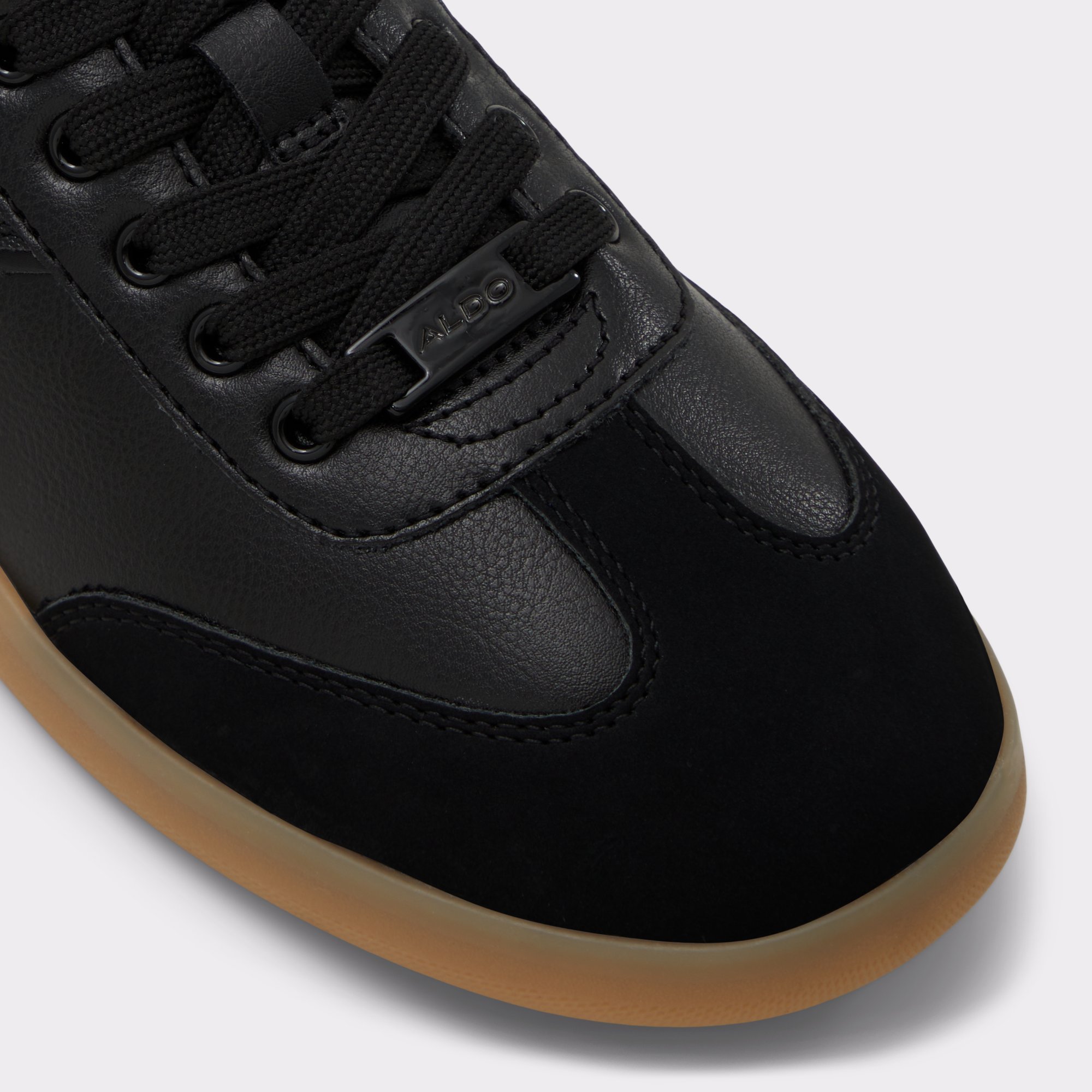 erilg_black_001-002-043_alt4_sq_gy_2000x2000 Close-up of black sneaker toe with gum sole