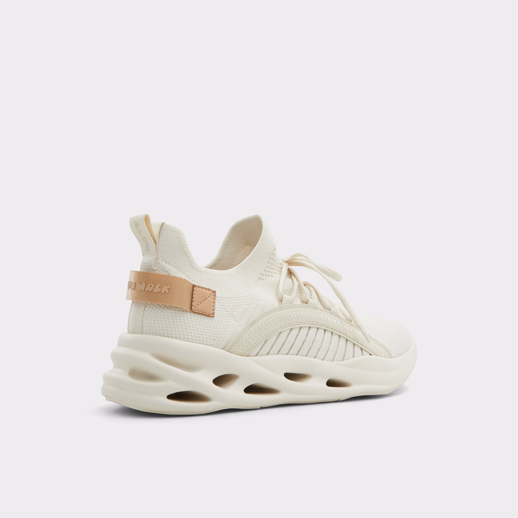 Cream athletic shoe with sculpted sole and tan strap