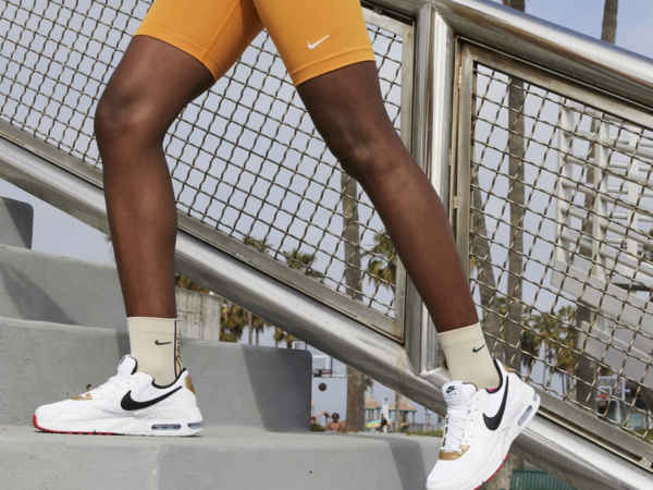 Person wearing white Nike sneakers climbing stairs