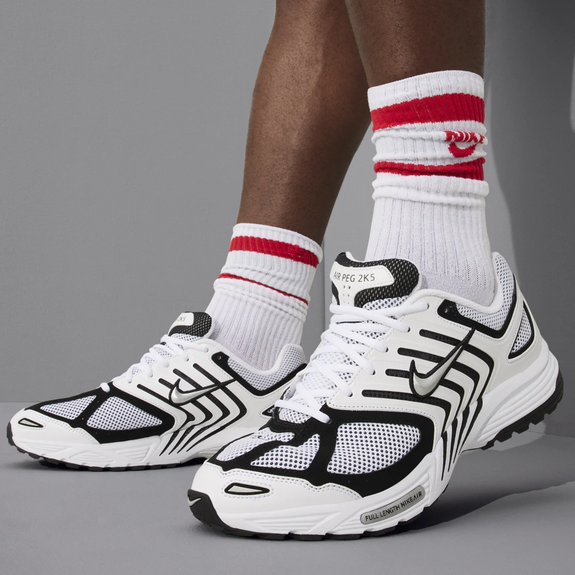 Person wearing black and white Nike sneakers with socks