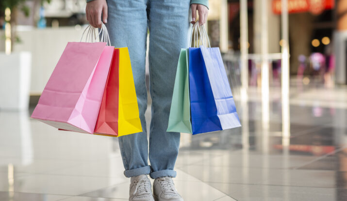 Person holding colorful shopping bags in mall