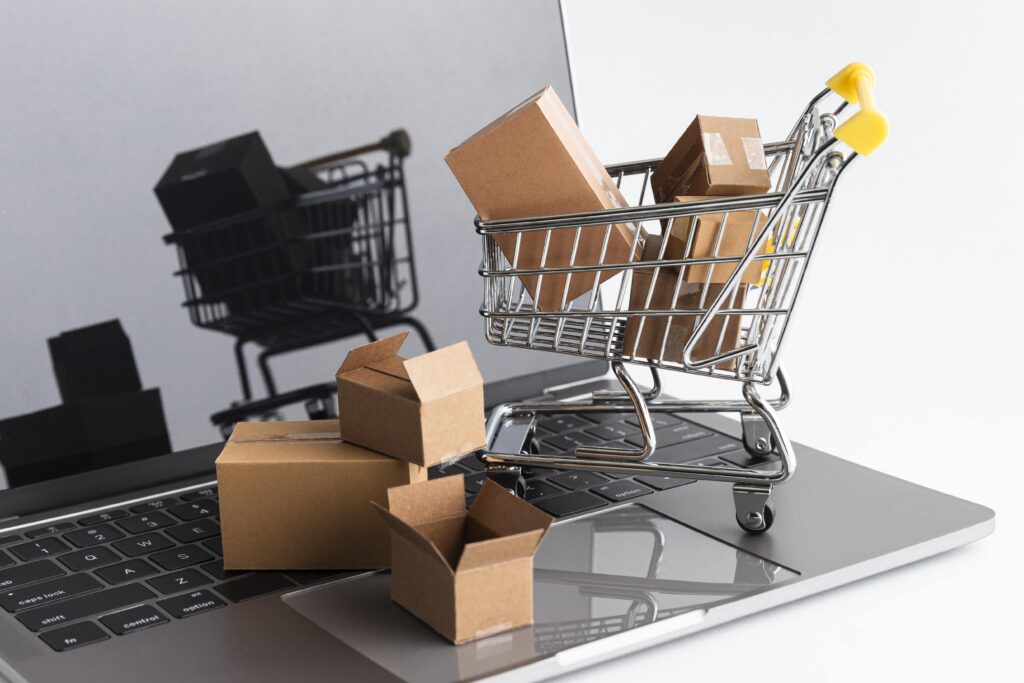Mini shopping cart with packages on laptop keyboard