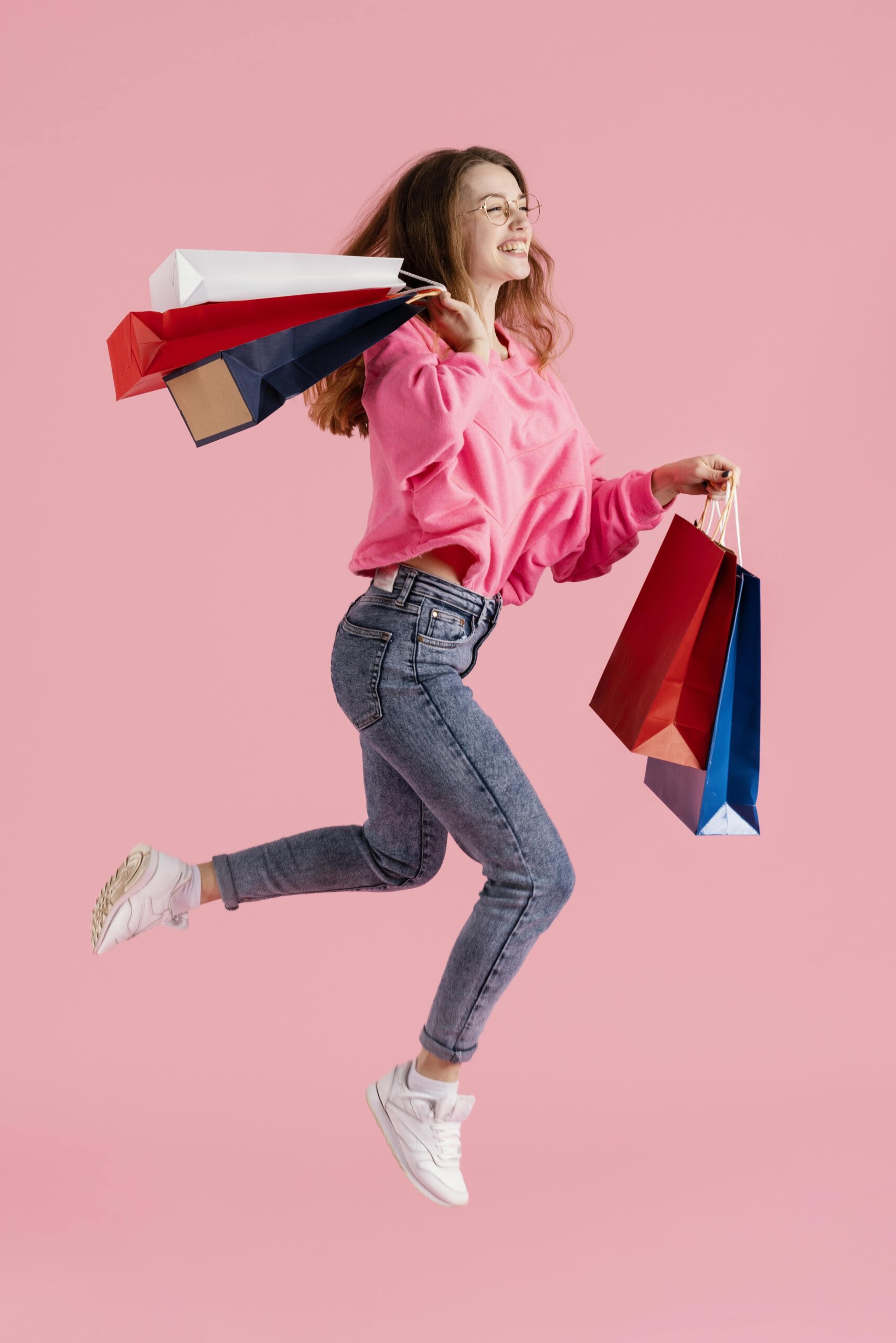 Woman jumping joyfully with colorful shopping bags