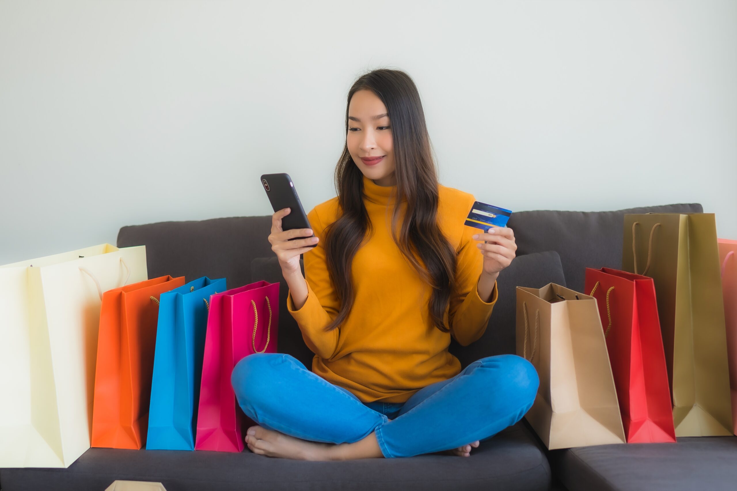 Woman online shopping with credit card and smartphone