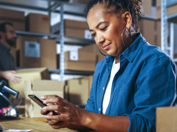 Woman using smartphone in warehouse workspace