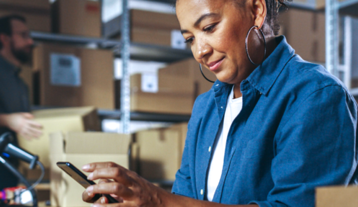 Woman using smartphone in warehouse workspace