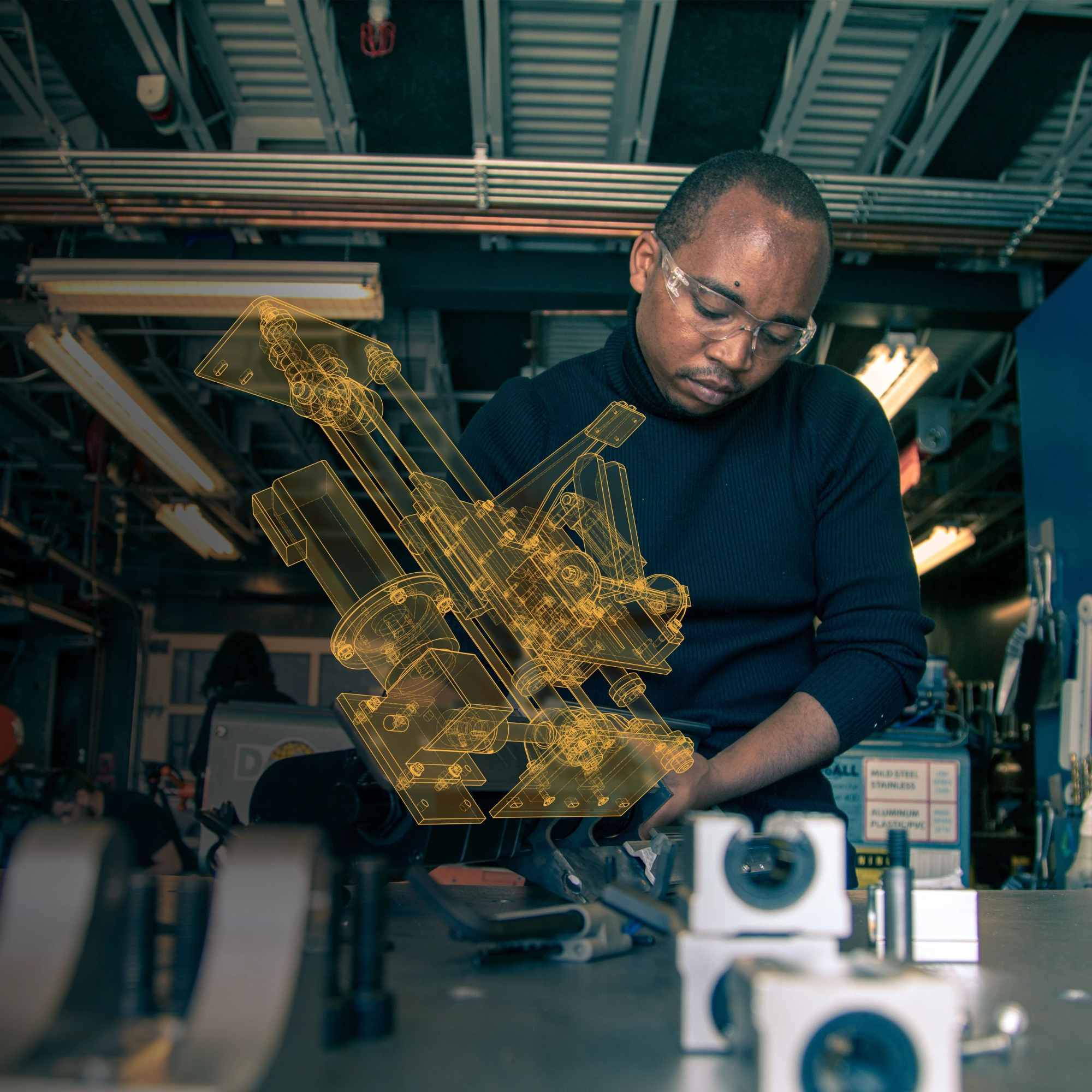 Engineer with safety glasses studying mechanical design model