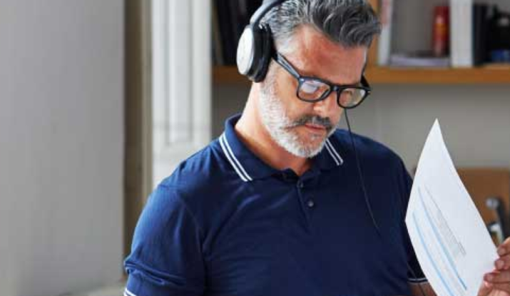 Man with headphones reviewing documents indoors