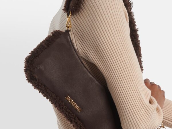 Woman carrying brown shearling Jacquemus shoulder bag