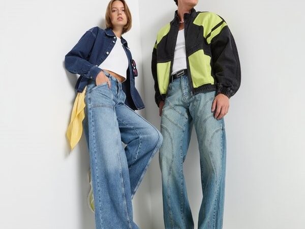 Two models wearing wide jeans and casual jackets