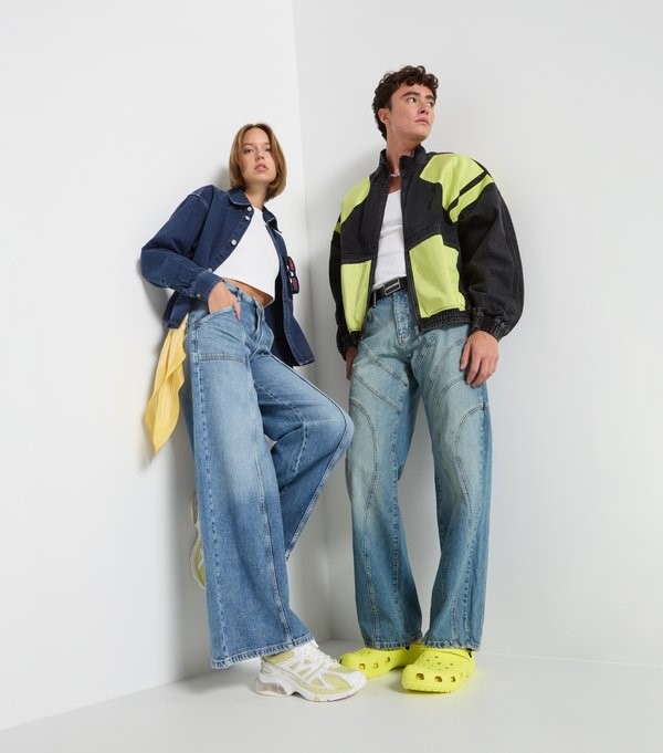 Two models wearing wide jeans and casual jackets